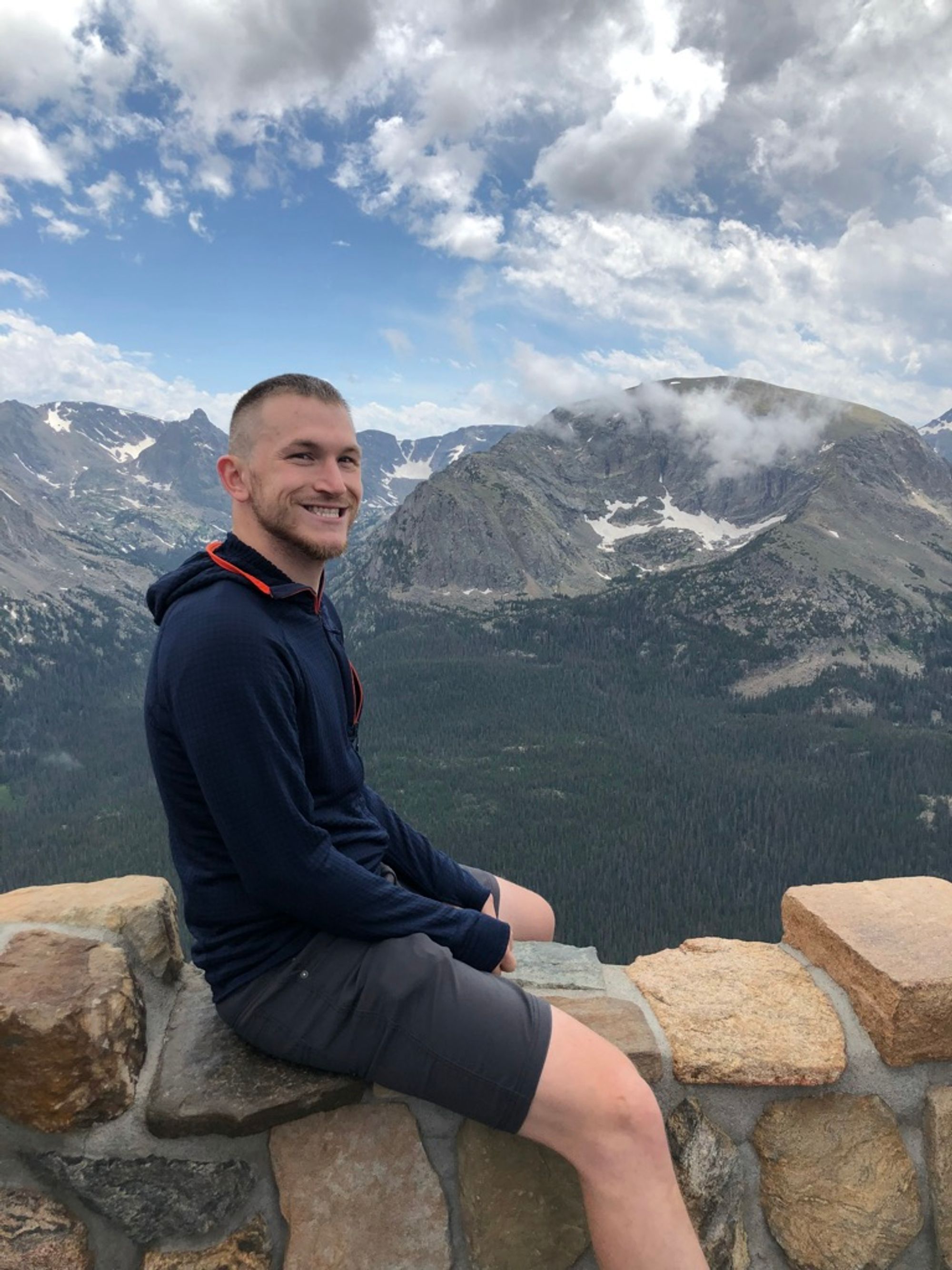 Me, sitting on a stone wall, overlooking the Rocky Mountains