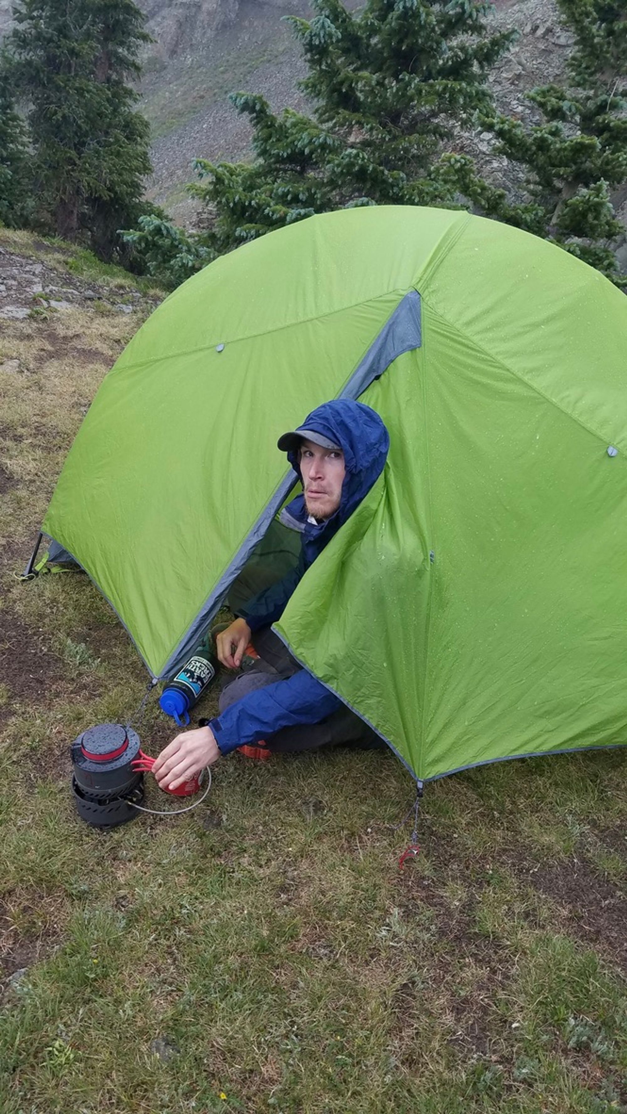 Me, in my raincoat, peaking out of my tent while trying to boil water in the rain/hail - my face is jokingly distraught.