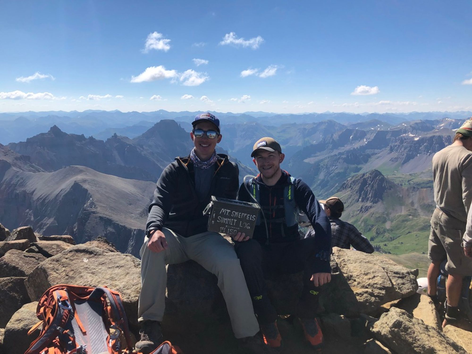 Me and Josh sitting atop the summit with the summit log (ammo can)